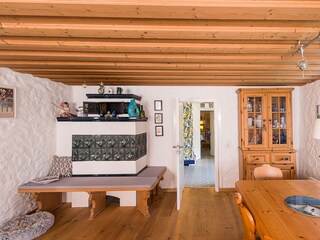 Living room with corner bench, stove and e-piano
