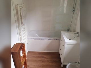 Bathroom with bathtub, shower and heated towel rail