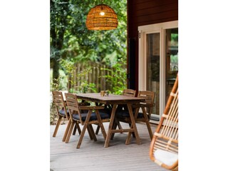 Gemütliche Veranda mit Hängesessel und Essgruppe