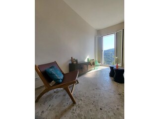 Wohnbereich mit bodentiefem Fenster und Blick ins Grüne