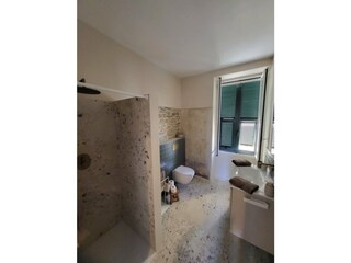 Badezimmer mit Dusche und Fenster