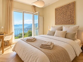 Gemütliches Schlafzimmer mit Queen-Size-Doppelbett und traumhafter See- und Bergsicht