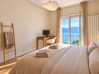 Gemütliches Schlafzimmer mit Queen-Size-Doppelbett und traumhafter See- und Bergsicht