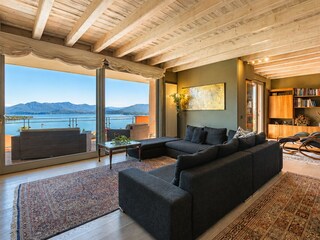Wohnzimmer mit Ausgang auf den Balkon und in den Garten sowie traumahafter Sicht auf die Orte Mèi...