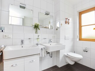 Badezimmer mit Badewanne, Dusche und zwei Waschbecken