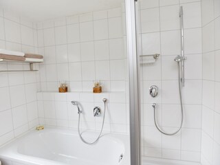 Badezimmer mit Badewanne, Dusche und zwei Waschbecken