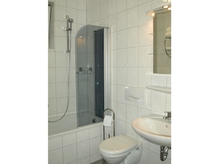 Badezimmer mit Badewanne und integrierter Dusche