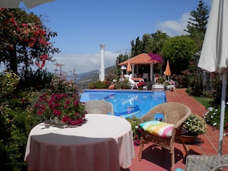 Terrasse mit Esstisch am Pool + Blick auf den Pavillon