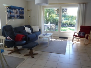 Wohnzimmer mit Blick in den Garten, dahinter Deich