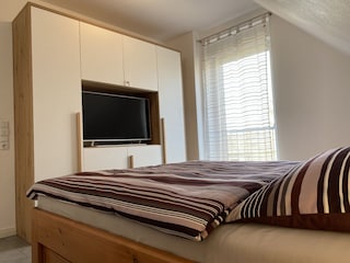 Schlafzimmer mit erhöhtem Doppelbett
