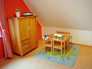 Kinder-Spielecke mit Spielzeug, Büchern und Malsachen.