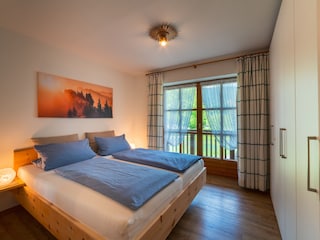 Schlafzimmer mit Zirbenbett und Balkon