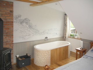 ... containing a large bathtub and a wood stove