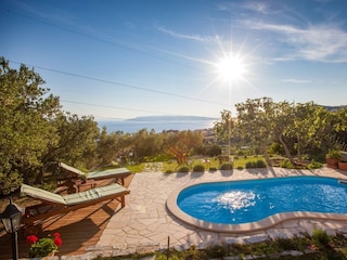 Der Pool mit Meerblick und Sonnenliegen