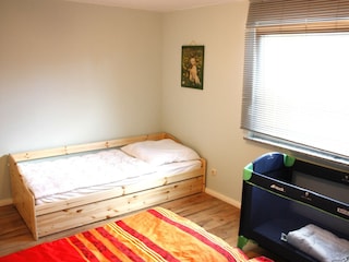 Blick vom Ehenett auf das Einzelbett mit Babybett