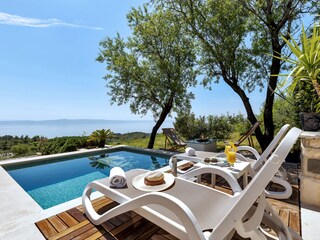 Der Pool mit Sonnenliegen und Meerblick