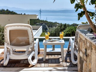 Der Pool mit Sonnenliegen und Meerblick