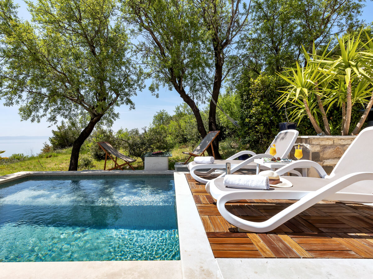 Der Pool mit Sonnenliegen und Meerblick