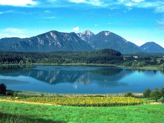 Hauslage mitte rechts im Bild zwischen See und Berg