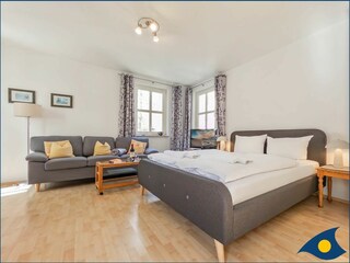 Wohn-/Schlafbereich mit Küchenzeile und Zugang zum Balkon