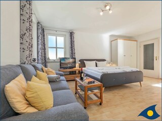 Wohn-/Schlafbereich mit Küchenzeile und Zugang zum Balkon