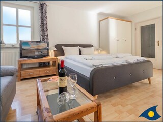 Wohn-/Schlafbereich mit Küchenzeile und Zugang zum Balkon