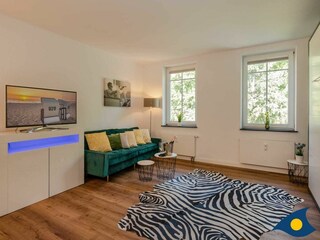 Wohnbereich mit Couch und Bett mit Schlaffunktion