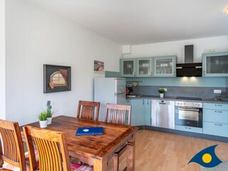 Wohn- / Essbereich mit offener Küche und Zugang zu Balkon