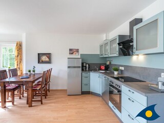 Wohn- / Essbereich mit offener Küche und Zugang zu Balkon