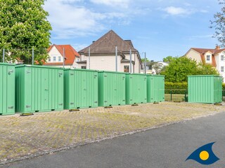 Parkplatz mit Abstellschuppen für Fahrräder etc.