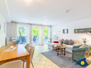 Wohnzimmer mit Schlafcouch und Zugang zum Balkon