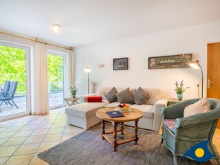 Wohnzimmer mit Schlafcouch und Zugang zum Balkon