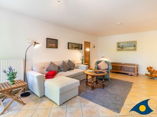 Wohnzimmer mit Schlafcouch und Zugang zum Balkon