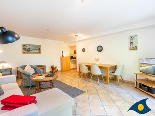 Wohnzimmer mit Schlafcouch und Zugang zum Balkon