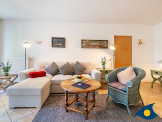 Wohnzimmer mit Schlafcouch und Zugang zum Balkon