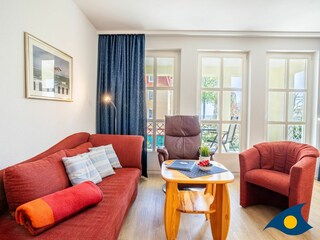 Wohn- / Essbereich mit offener Küche und Zugang zu Balkon