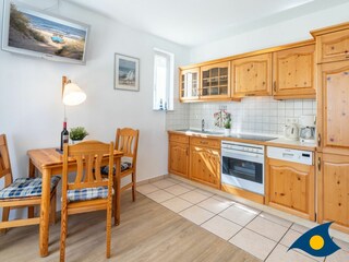 Wohn- / Essbereich mit offener Küche und Zugang zu Balkon