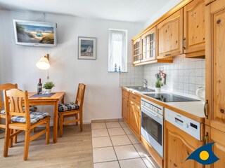 Wohn- / Essbereich mit offener Küche und Zugang zu Balkon