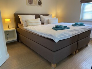 2. Schlafzimmer im OG mit Boxspringbett, Loggia und TV