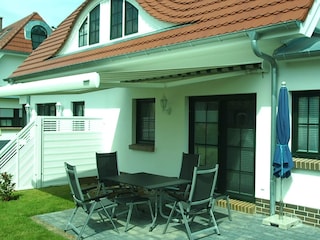 Terrasse mit großer elektrischer Markise, Gartenmöbel