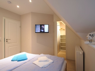 1. Schlafzimmer mit Blick auf begehbaren Kleiderschrank