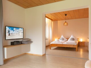 Wohnzimmer und Blick ins 1. Schlafzimmer