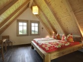 Schlafzimmer mit rustikalem Doppelbett