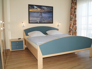 Schlafzimmer mit großem TV an der Wand