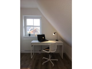 Schreibtisch und offener Kleiderschrank auf der Empore